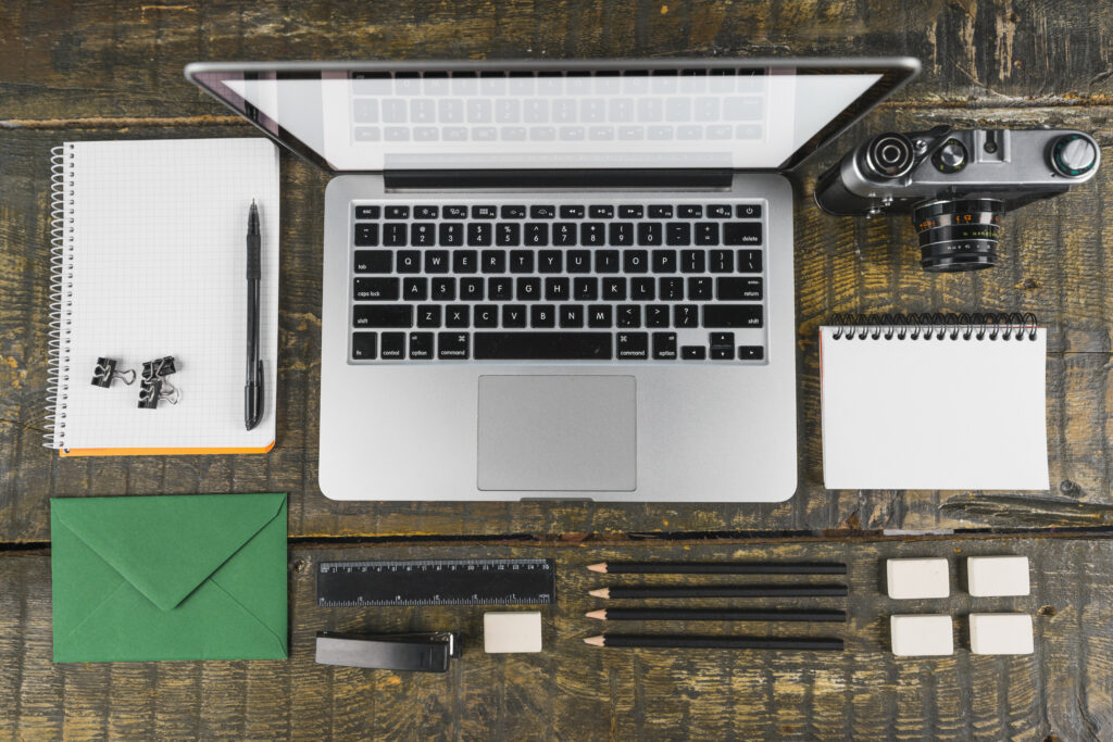 overhead view arranged office stationeries laptop retro camera wooden desk